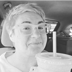 Adriel holding a milkshake up to the camera in a classy black and white photo