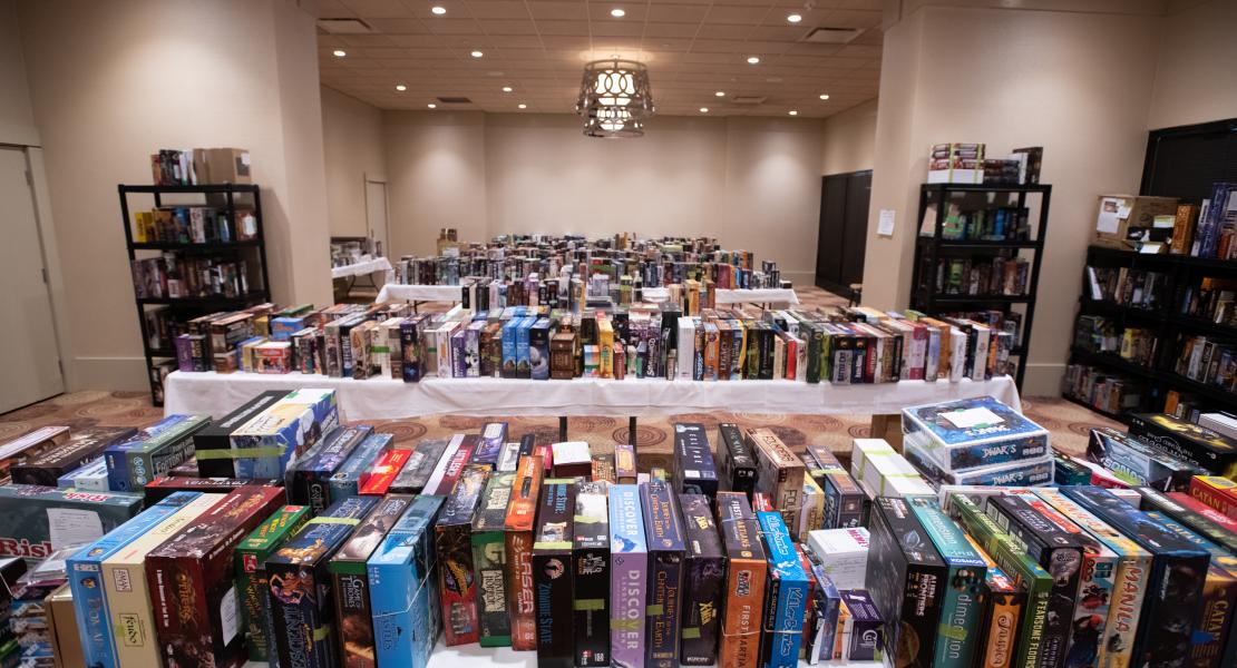 The auction room tables filled with boardgames - no people in the room